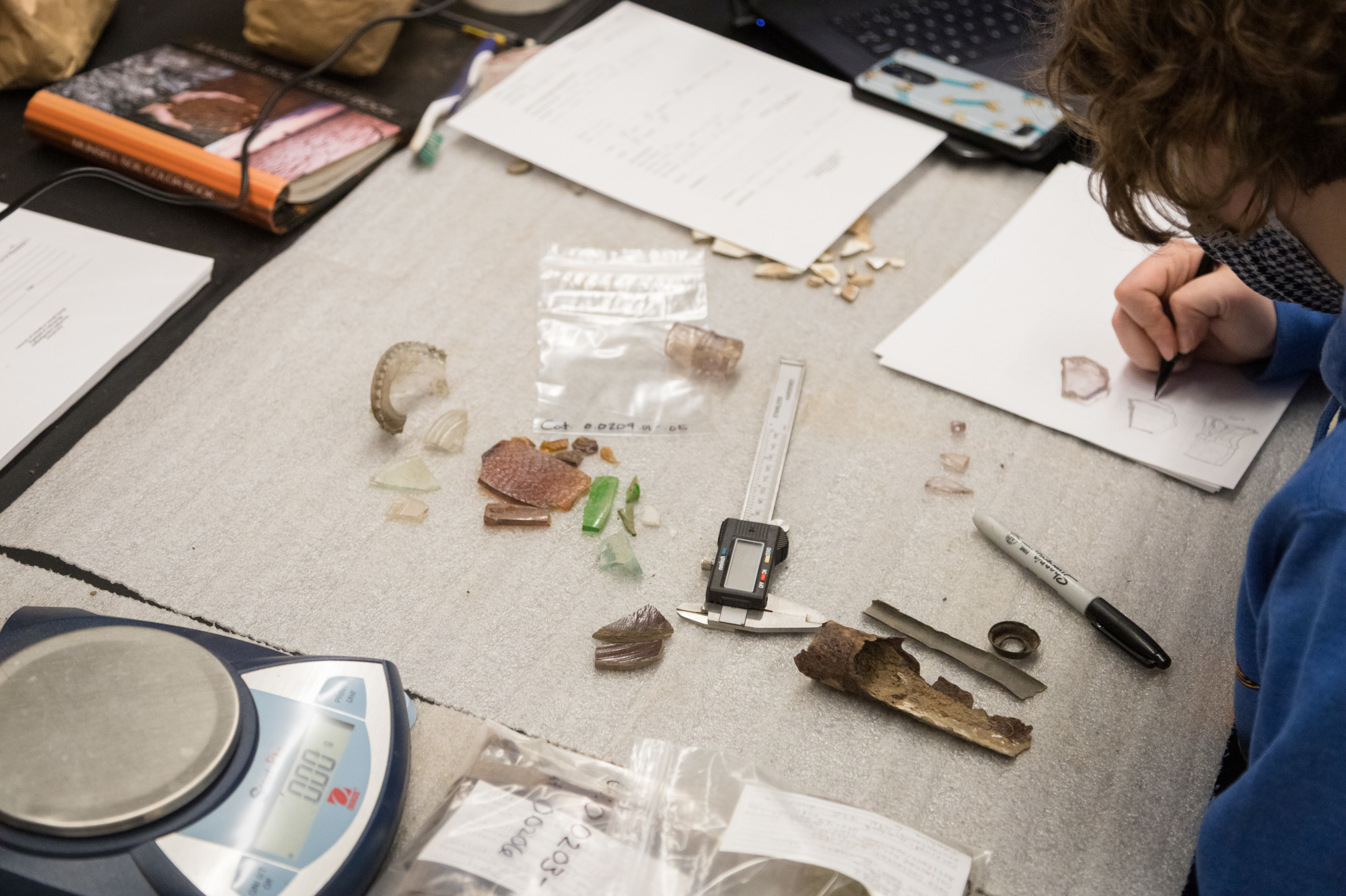 hands working on materials in archaeology lab