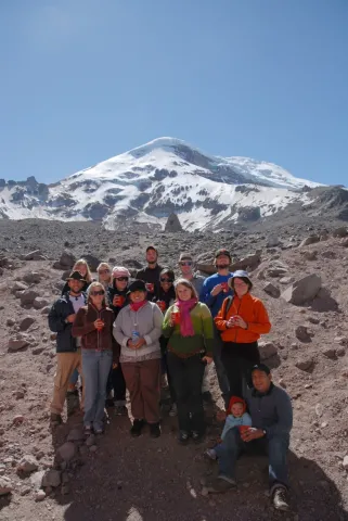 Group of people posing in front of a mountain 